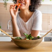young unrecognisable multiracial african american eating tomato from fresh salad.healthy eating. - food stock pictures, royalty-free photos & images