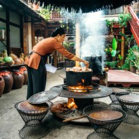 young vietnamese woman cooking steamed fish on open fire in restaurant - food stock pictures, royalty-free photos & images