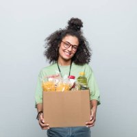 young volunteer holding donation box - food stock pictures, royalty-free photos & images
