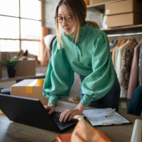 young woman accepting new orders in her e-commerce fashion store - fashion stock pictures, royalty-free photos & images
