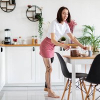 young woman amputee with prosthesis arranging food and kitchen utensils at home - home decoration stock pictures, royalty-free photos & images