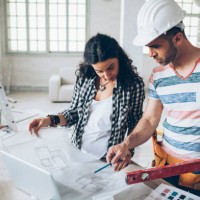 young woman and construction worker looking at blueprints - home decoration stock pictures, royalty-free photos & images