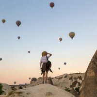 young woman and hot air ballons, goreme, cappadocia, turkey - travel stock pictures, royalty-free photos & images
