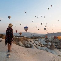 young woman and hot air balloons in the evening, goreme, cappadocia, turkey - travel stock pictures, royalty-free photos & images
