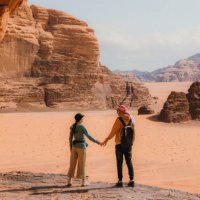young woman and man traveler contemplating the scenic landscape of wadi rum desert - travel stock pictures, royalty-free photos & images