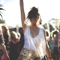 young woman at a summer music festival wearing golden sequinned hot pants, dancing among the crowd. - fashion stock pictures, royalty-free photos & images