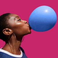 young woman blowing balloon against pink background - fashion stock pictures, royalty-free photos & images