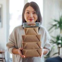 young woman carrying takeaway food boxes - junk food stock pictures, royalty-free photos & images