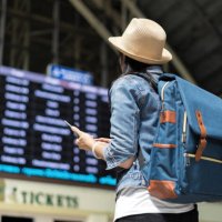 young woman checking her train in timetable board - travel stock pictures, royalty-free photos & images