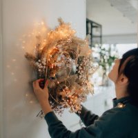 young woman decorating her living room for the upcoming holidays - home decoration stock pictures, royalty-free photos & images