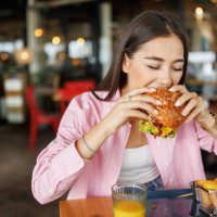 young woman dining in fast food restaurant - junk food stock pictures, royalty-free photos & images