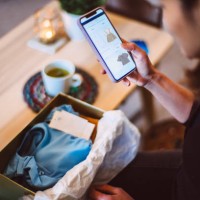 young woman doing online shopping for clothes on smartphone at home - fashion stock pictures, royalty-free photos & images
