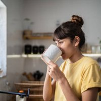 young woman drinking coffee or tea at home - coffee stock pictures, royalty-free photos & images