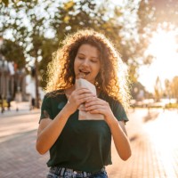 young woman eating a pastry on the street - junk food stock pictures, royalty-free photos & images