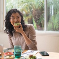 young woman eating avocado toast at home - food stock pictures, royalty-free photos & images