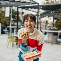 young woman eating fast food - junk food stock pictures, royalty-free photos & images