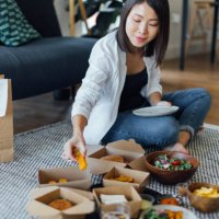 young woman eating fast food at home - junk food stock pictures, royalty-free photos & images