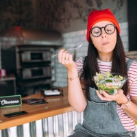 young woman eating salad - food stockfoto's en -beelden