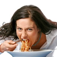 young woman eating spaghetti - junk food stockfoto's en -beelden