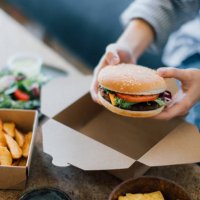 young woman eating takeaway food - junk food stock pictures, royalty-free photos & images