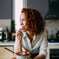 young woman enjoying a healthy breakfast at home - food stockfoto's en -beelden