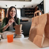 young woman enjoying takeaway food at home - junk food stock pictures, royalty-free photos & images
