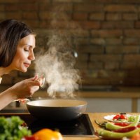 young woman enjoying while cooking meal in the kitchen. - food stock pictures, royalty-free photos & images