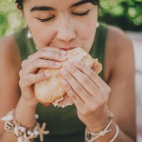 young woman enjoys a serrano ham sandwich outdoors - food stock pictures, royalty-free photos & images