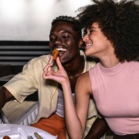young woman feeding her boyfriend on restaurant - food stock pictures, royalty-free photos & images