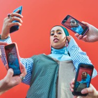 young woman having picture taken by multiple smartphones. - fashion stock pictures, royalty-free photos & images