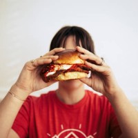 young woman holding a large sandwich - junk food stock pictures, royalty-free photos & images