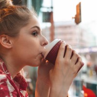 young woman in a cafe drinking a coffee - junk food stock pictures, royalty-free photos & images