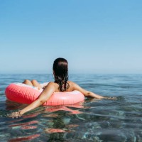 young woman in a sprinkled doughnut float at the beach - fashion stock pictures, royalty-free photos & images