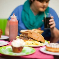 young woman in cafe with table of food - junk food stock pictures, royalty-free photos & images