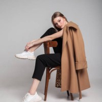 young woman in elegant coat sitting on the chair - fashion stock pictures, royalty-free photos & images