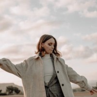 young woman in warm clothing looking away while in the meadow at sunrise standing against sky,france - fashion stock pictures, royalty-free photos & images