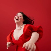 young woman laughing against red background - fashion stock pictures, royalty-free photos & images