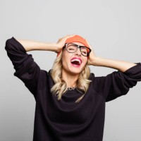young woman laughing with hands in head - fashion stock pictures, royalty-free photos & images