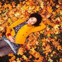 young woman lying down on yellow leaves - fashion stock pictures, royalty-free photos & images