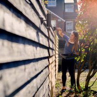 young woman painting garden fence in the sun - home decoration stock pictures, royalty-free photos & images