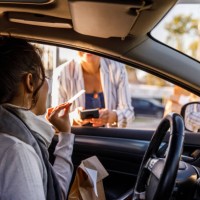 young woman paying with a credit card at the curbside pickup - junk food stock pictures, royalty-free photos & images