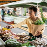 young woman paying with mobile phone at a street market - food stock pictures, royalty-free photos & images