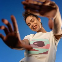young woman posing outdoors against a clear blue sky, her fashionable attire shining under the natural light - fashion stock pictures, royalty-free photos & images