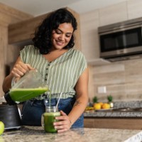 young woman preparing detox juice in kitchen at home - food stock pictures, royalty-free photos & images