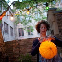 young woman preparing paper lantern in back yard for garden party - garden decoration stock pictures, royalty-free photos & images