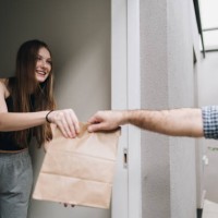 young woman receiving food delivery at home - food stock pictures, royalty-free photos & images
