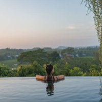 young woman relaxes on edge of swimming pool - travel stock-fotos und bilder