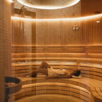 young woman relaxing and sweating in hot sauna wrapped in towel. - fashion stock pictures, royalty-free photos & images