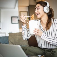 young woman relaxing at home and eating pasta - junk food stock pictures, royalty-free photos & images