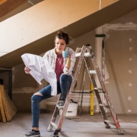 young woman renovating her new home, holding construction plan - home decoration stock pictures, royalty-free photos & images